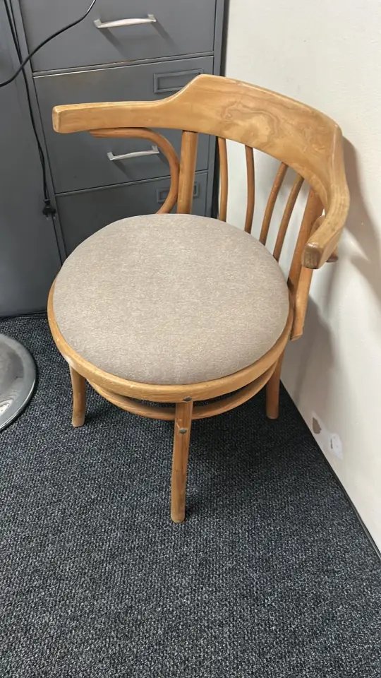 A bentwood chair with a round upholstered seat