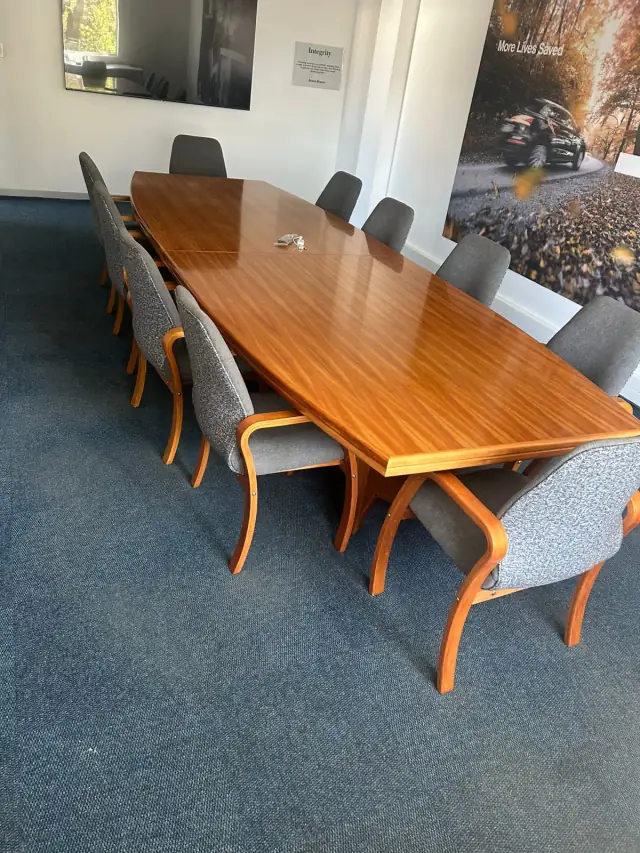 A boardroom table with grey upholstered chairs