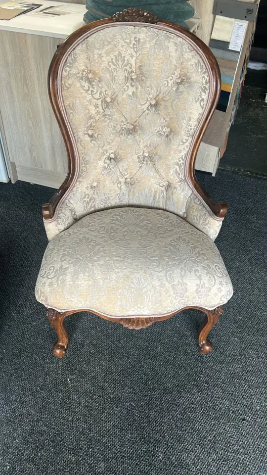 A buttoned Victorian chair in cream damask