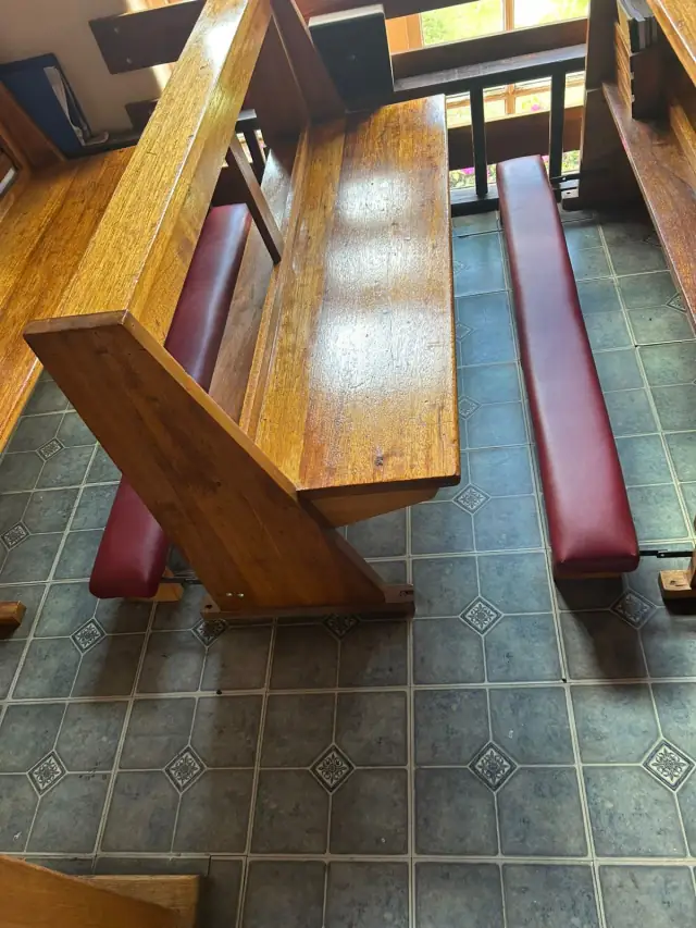 Church pews with red seat cushions