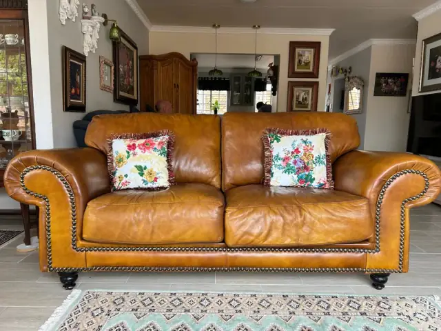 A tan leather sofa with brass studs