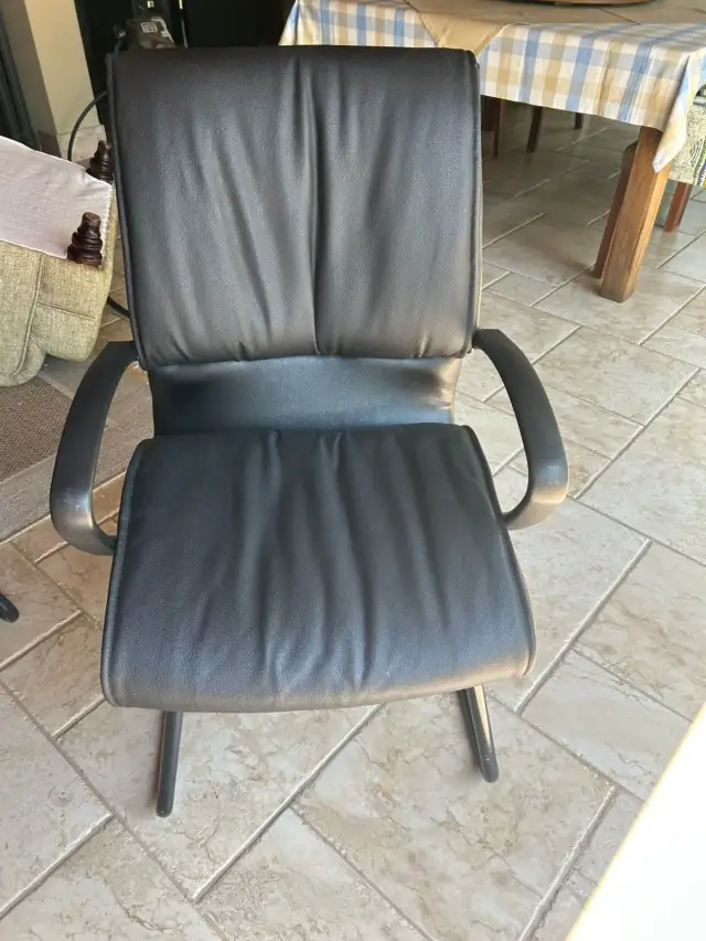 A black leather office chair on a cantilever frame