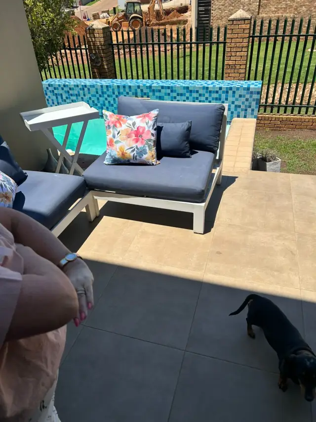 Patio seating with navy cushions beside a pool
