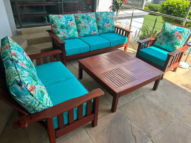 A patio set with turquoise cushions and tropical-print scatter cushions