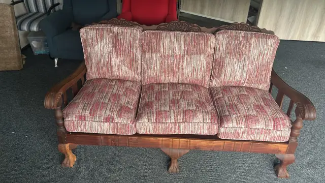 A three-seater with carved wooden arms, in a red and cream weave