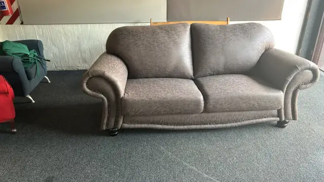 A two-seater with rolled arms in a grey-brown fabric