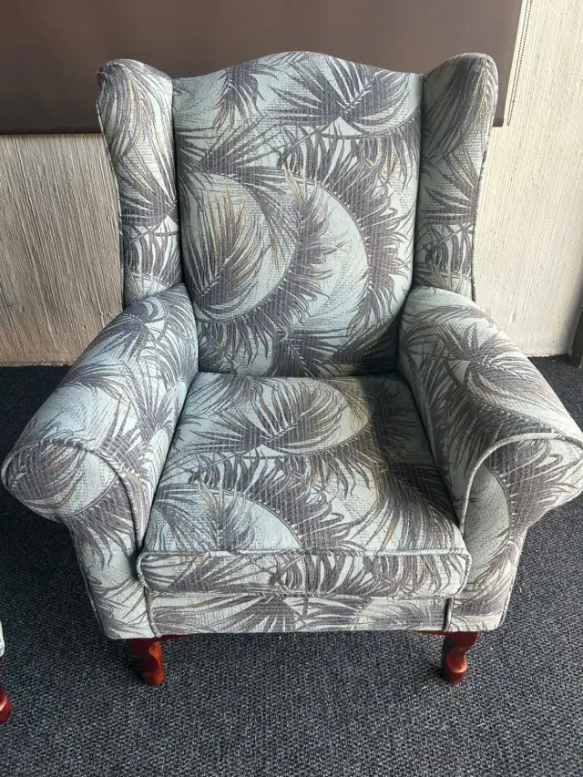 A wingback chair in a palm-leaf print